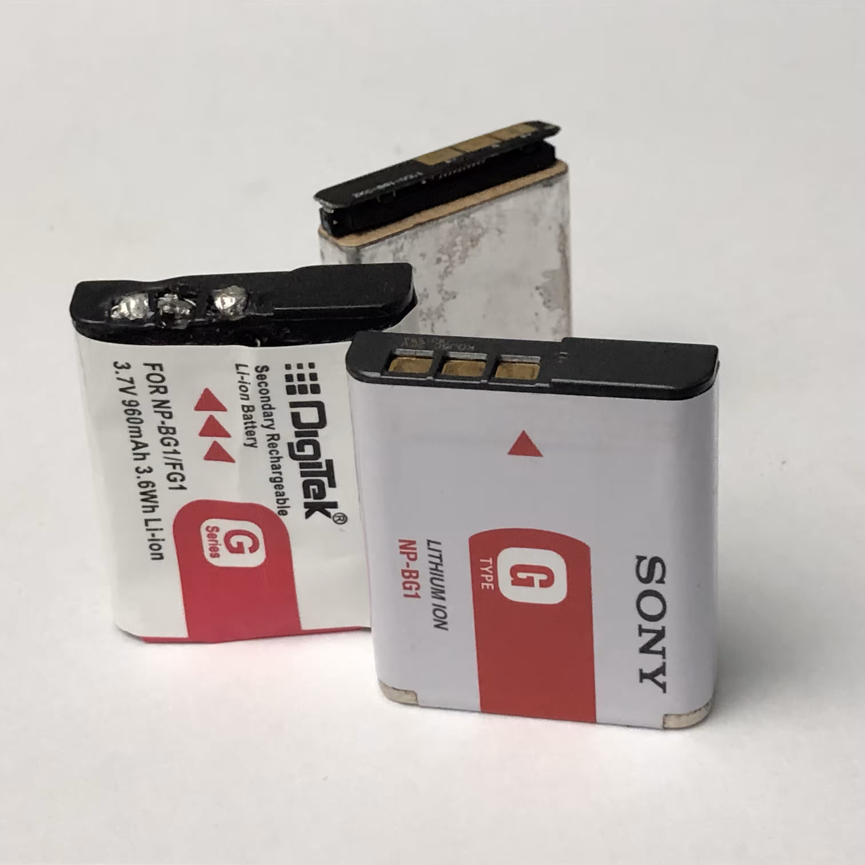 all three batteries side by side, with the misshapen molten contacts on the dummy showing prominently