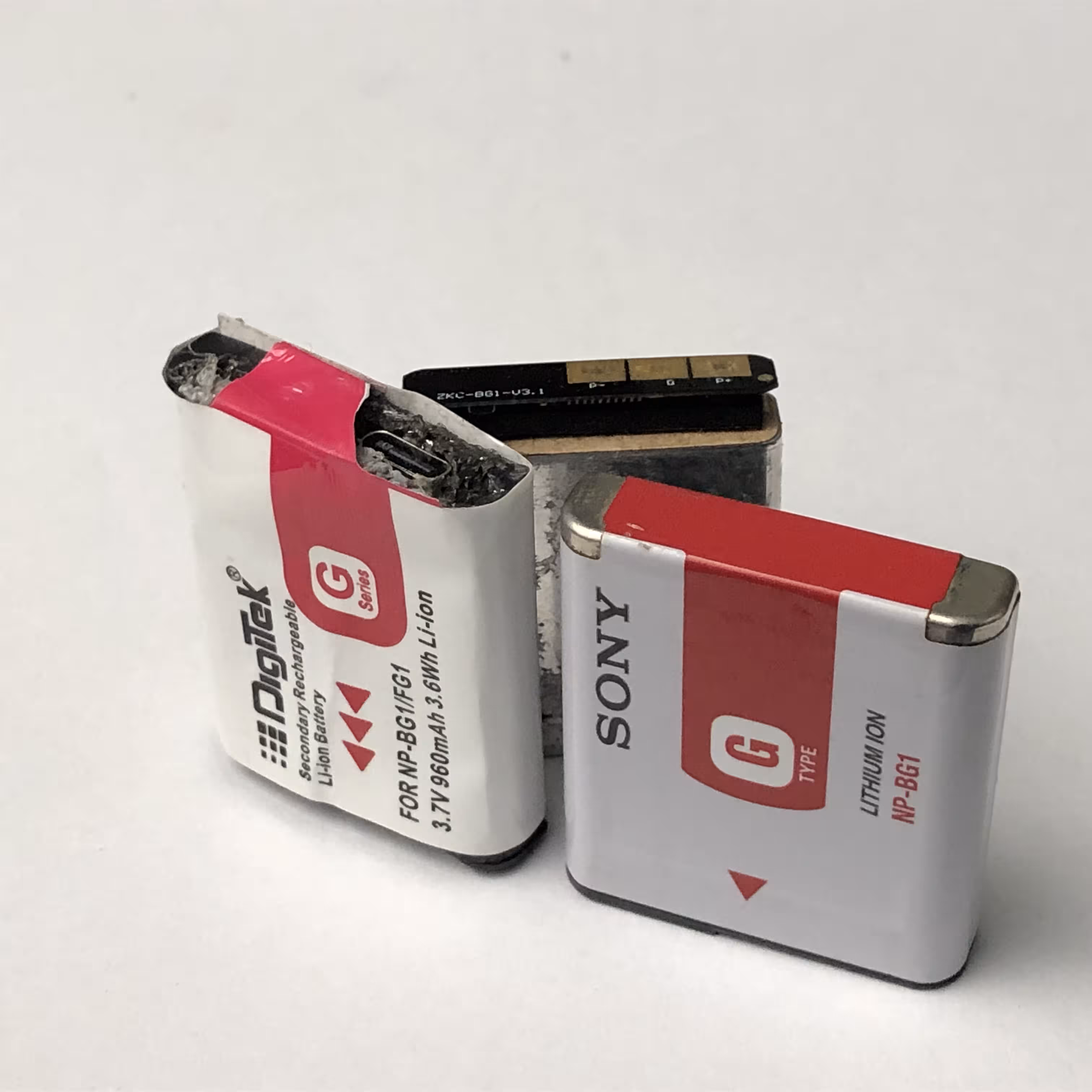 all three batteries side by side, with the usb c port on the dummy showing prominently